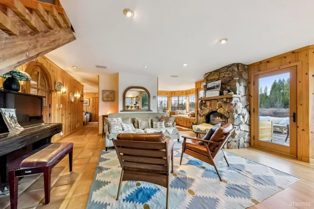 a living room with furniture a flat screen tv and a floor to ceiling window