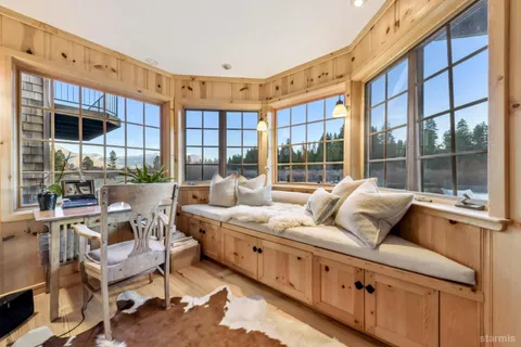 a living room with furniture large windows a wooden floor and windows