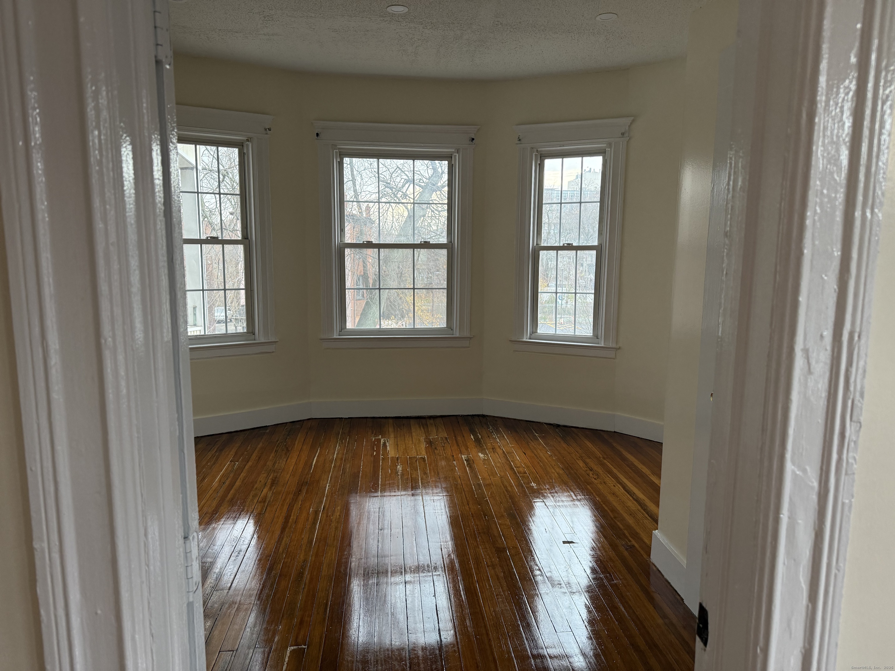 204 Homestead Avenue, Unit 3 Hartford, CT 06112 - Photo 3 of 7 a view of an empty room with wooden floor and a window