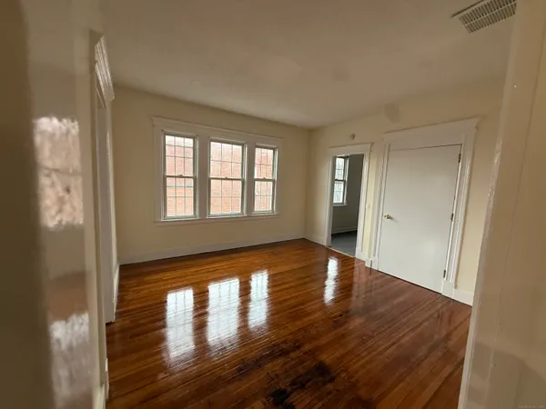 a view of a hallway with wooden floor