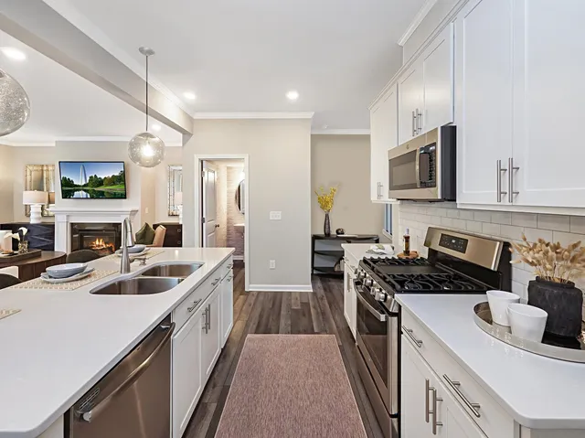 a kitchen that has a sink a stove and cabinets