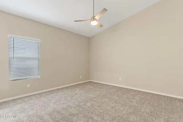 an empty room with a window and a fan