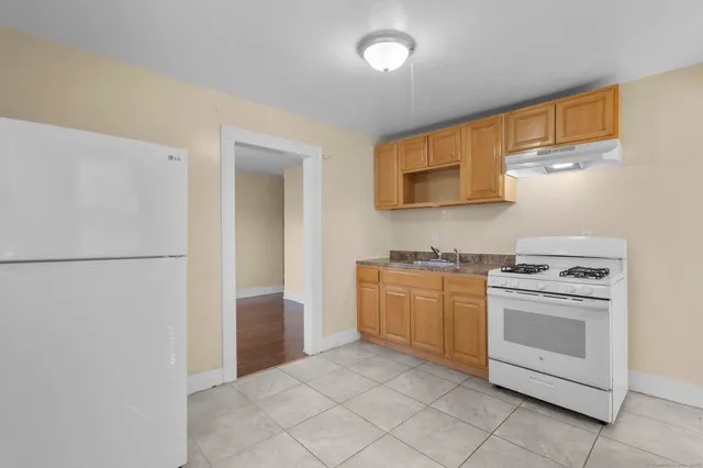 a kitchen with a stove top oven and refrigerator