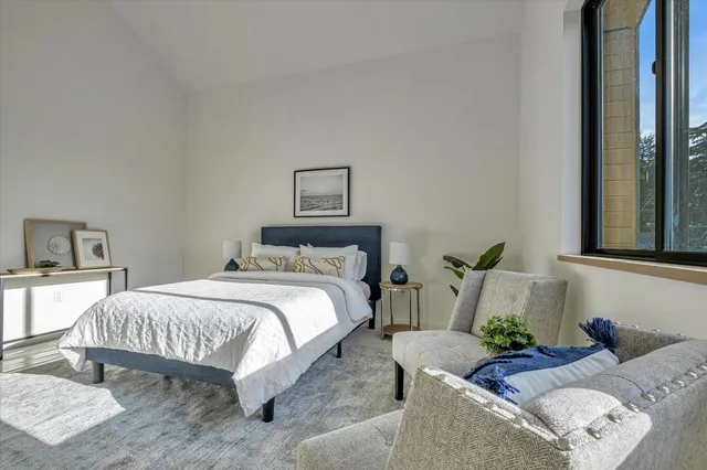 a bedroom with bed couch and window