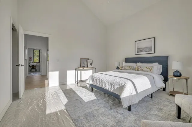 a spacious bedroom with a bed and a view of bedroom