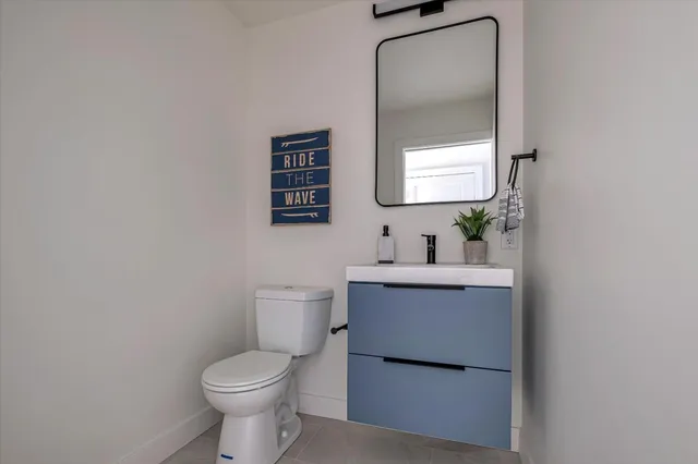 a bathroom with a toilet sink vanity and mirror