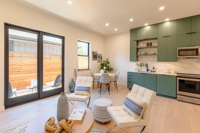 a living room with furniture a large window with kitchen view