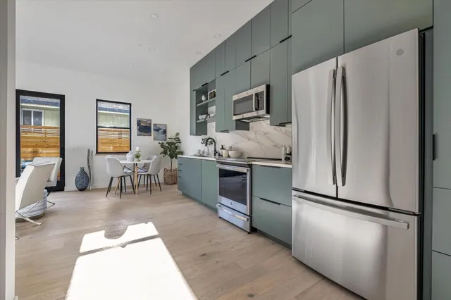 a kitchen with stainless steel appliances a refrigerator sink and cabinets