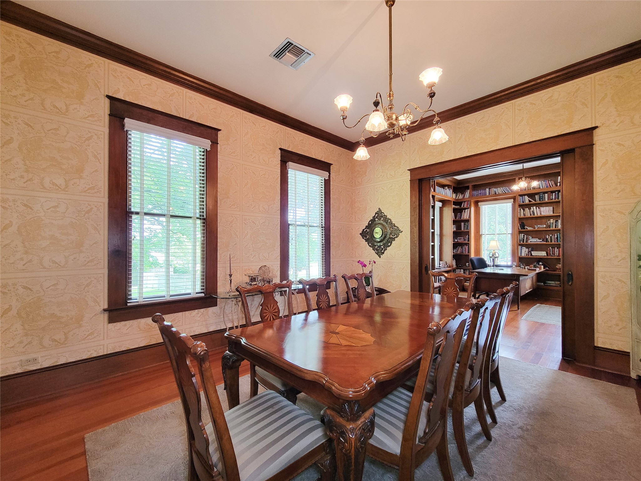 1406 Key Street Brenham, TX 77833 - Photo 8 of 50 Elegant formal dining room with rich wood trim, an antique chandelier, and hardwood floors—ideal for entertaining.