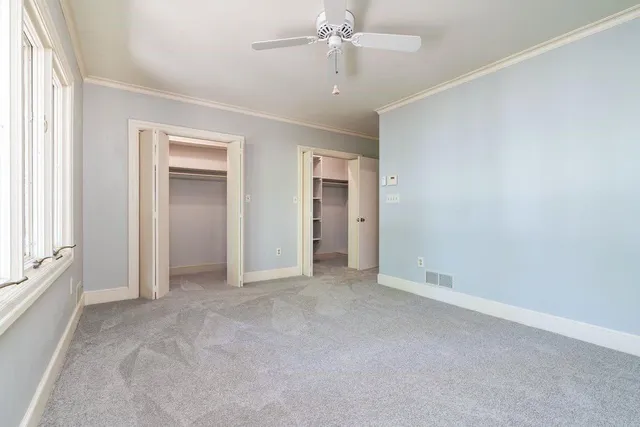 an empty room with fan and entrance