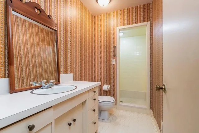 a bathroom with a sink a toilet and shower curtain