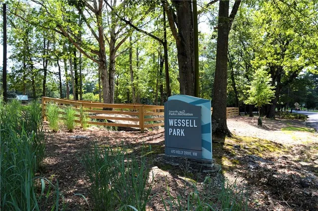 a sign board with a house and yard at the back