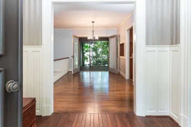 a view of a hallway with wooden floor fireplace and dining room
