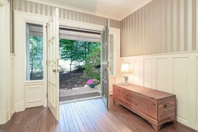 a room with a large window and wooden floor