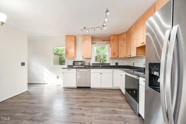a kitchen with stainless steel appliances a refrigerator sink and microwave