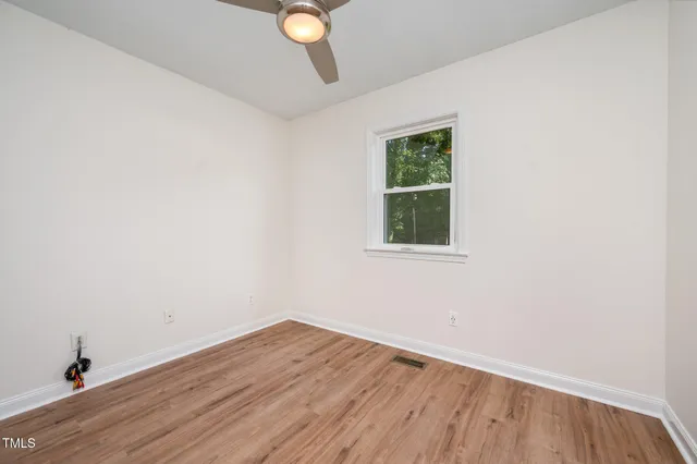 a view of a room with wooden floor and fan