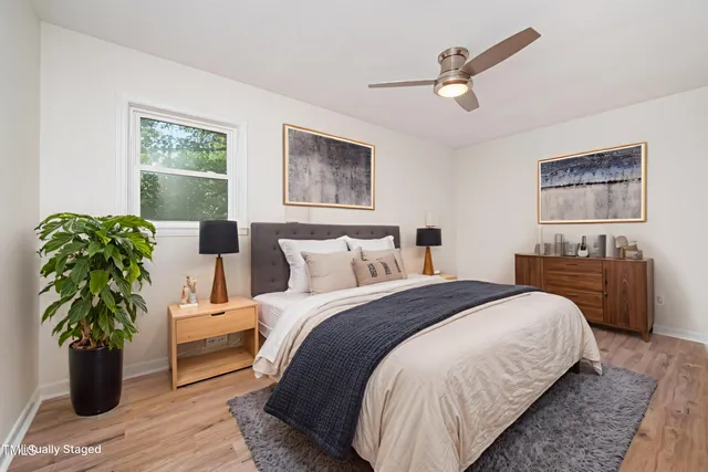 a spacious bedroom with a bed and a potted plant