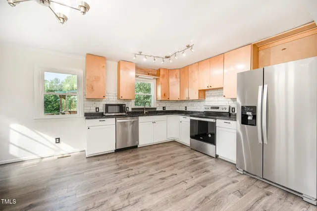a kitchen with stainless steel appliances a refrigerator sink and cabinets