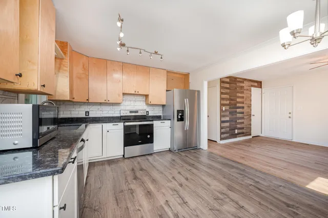 a kitchen with granite countertop a stove cabinets and wooden floor