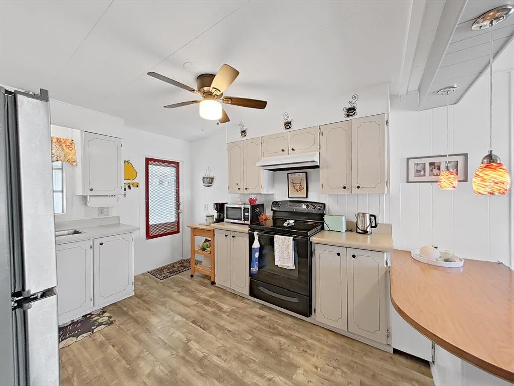 9900 Ulmerton Road, Unit 238 Largo, FL 33771 - Photo 5 of 22 a kitchen that has a lot of white cabinets and stainless steel appliances