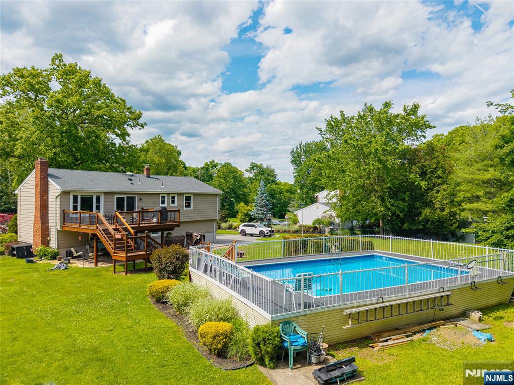 55 Marcia Road Ringwood, NJ 07456 - Photo 3 of 42 a view of a swimming pool with lawn chairs and plants