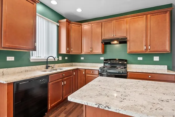 a kitchen with stainless steel appliances granite countertop a stove a sink and a microwave