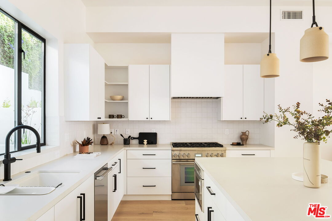 762 North Arthur Road Los Angeles, CA 90029 - Photo 4 of 30 a kitchen with a sink stove and cabinets