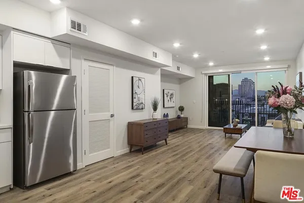 a living room with furniture and a refrigerator