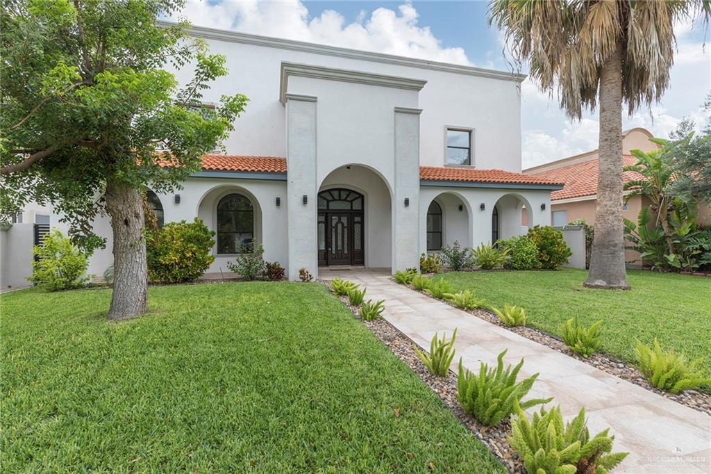 2216 South 45th Street McAllen, TX 78503 - Photo 2 of 40 a front view of a house with a garden and palm trees