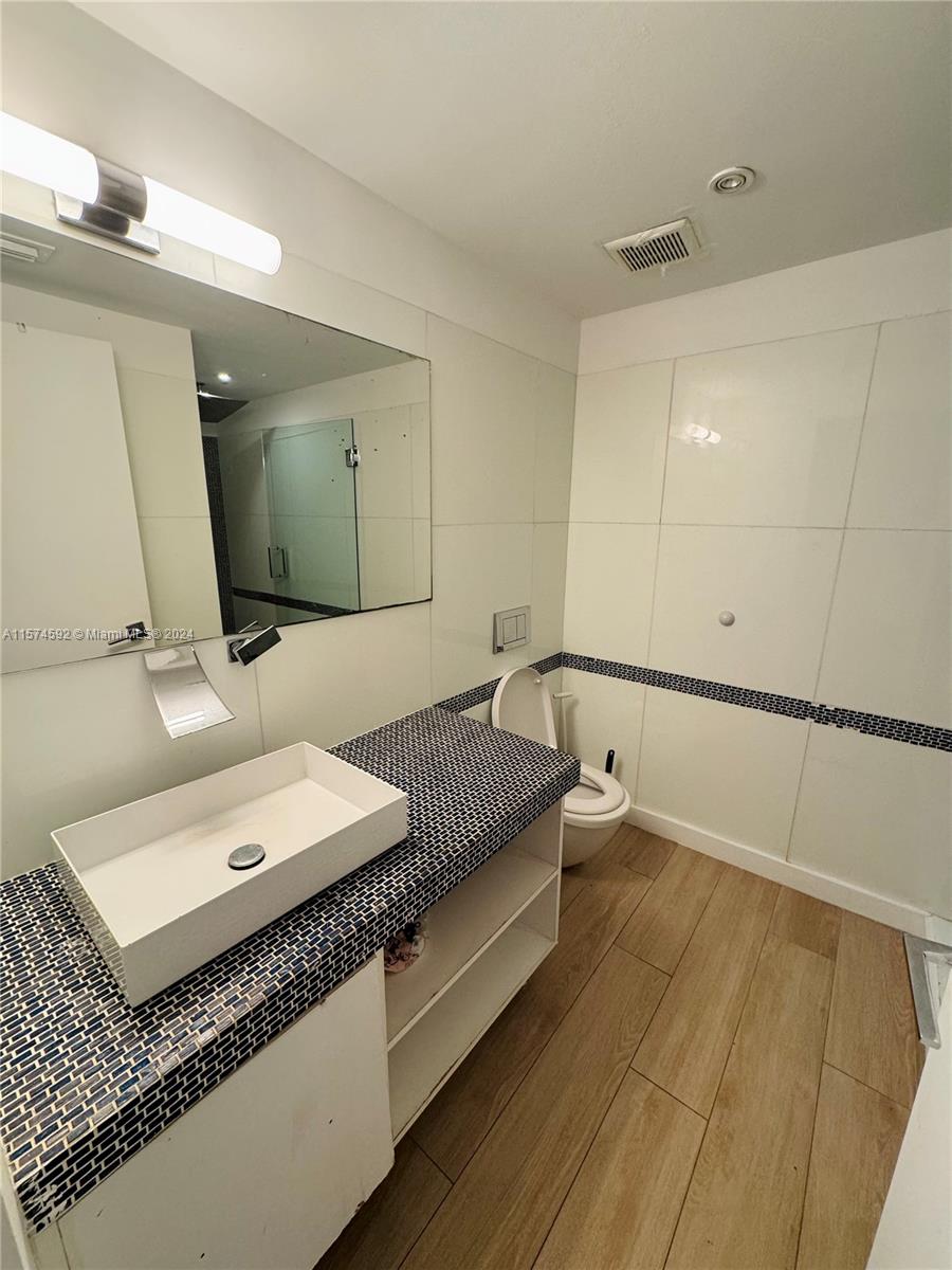 700 16th Street, Unit 108 Miami Beach, FL 33139 - Photo 5 of 10 a bathroom with a double vanity sink and mirror