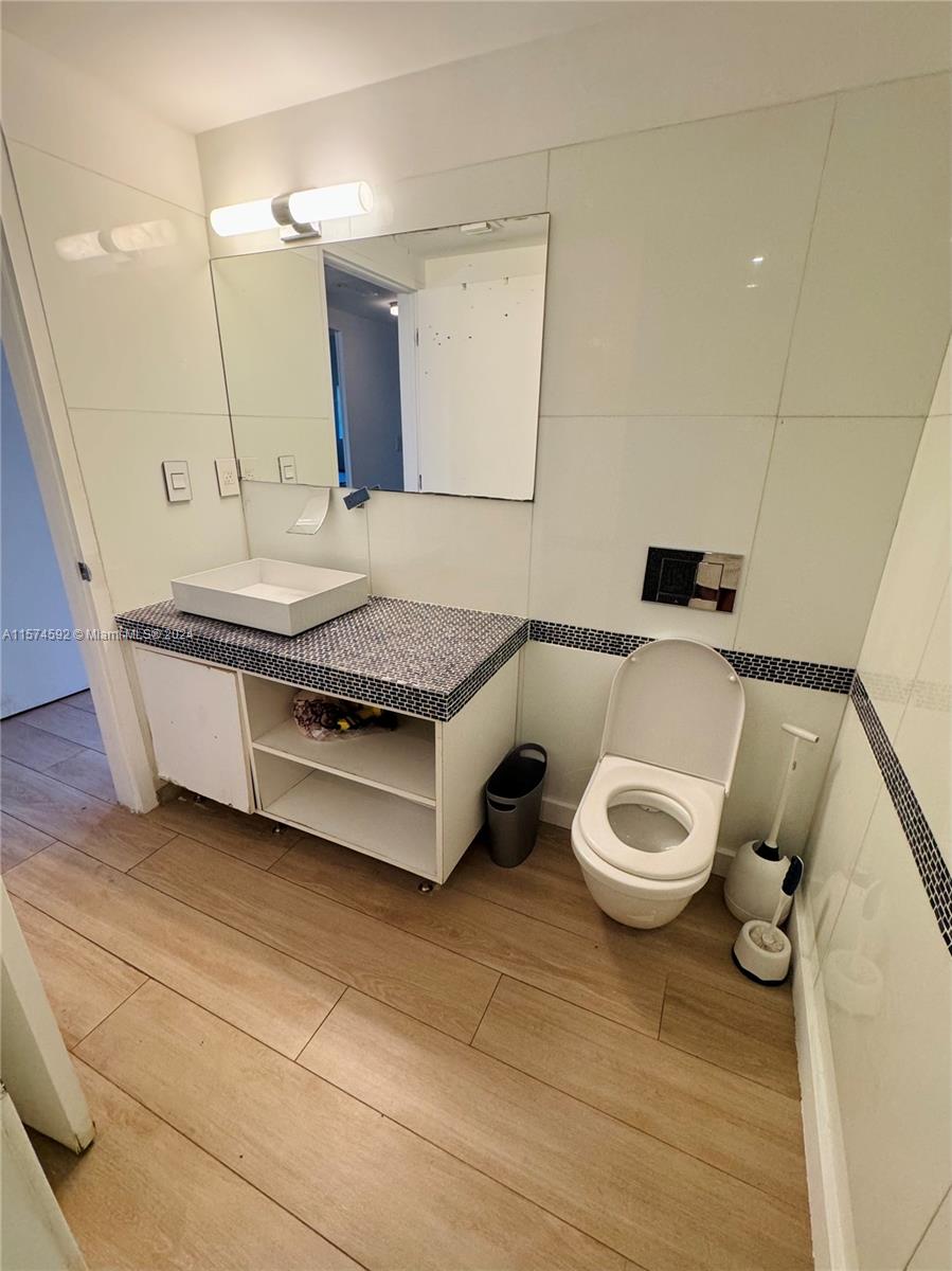700 16th Street, Unit 108 Miami Beach, FL 33139 - Photo 6 of 10 a spacious bathroom with a granite countertop toilet sink and mirror