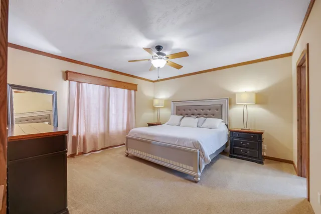 a spacious bedroom with a bed and a chandelier
