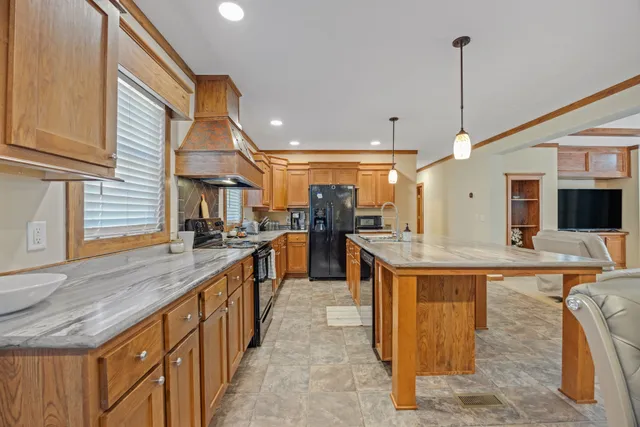 a kitchen with stainless steel appliances granite countertop a sink and a wooden floor