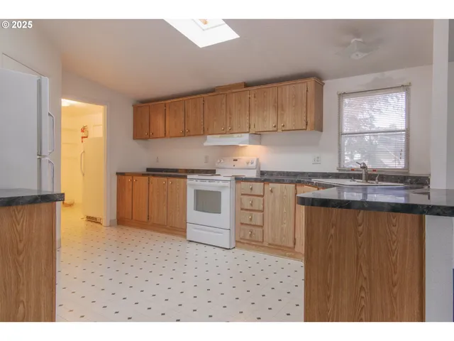 a kitchen with granite countertop a sink stainless steel appliances and cabinets