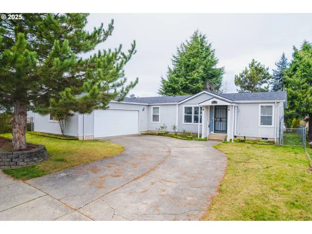 a front view of a house with a yard and trees