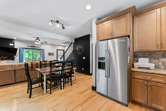 a kitchen with stainless steel appliances granite countertop a refrigerator dining table and chairs