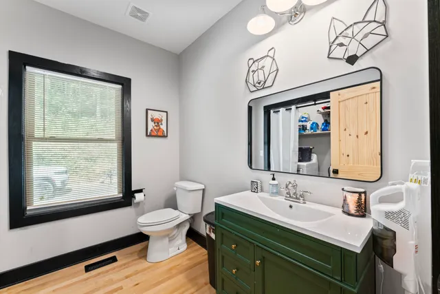 a bathroom with a granite countertop sink mirror vanity and toilet