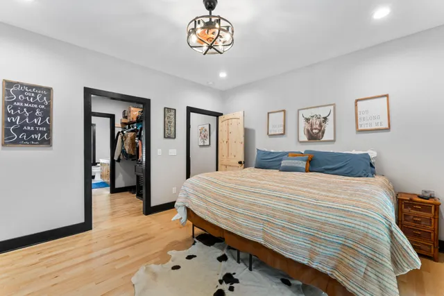 a bedroom with a large bed and a chandelier