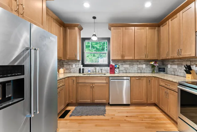 a kitchen with stainless steel appliances granite countertop a refrigerator sink and cabinets
