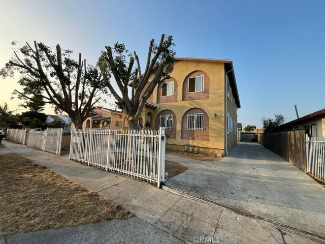 a view of a brick house with large windows and a yard