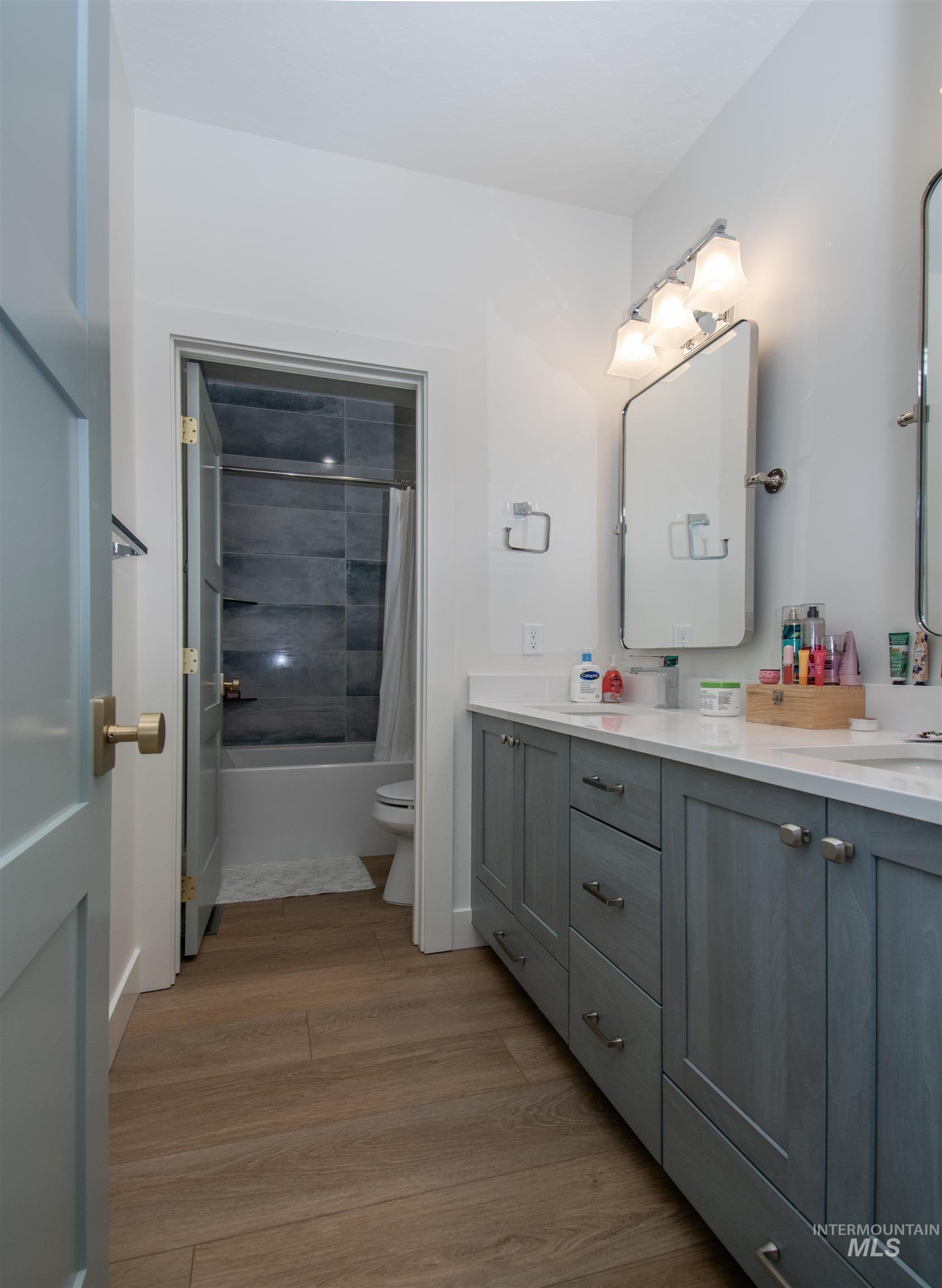 44 Big Moose Road McCall, ID 83638 - Photo 24 of 50 Bathroom featuring a double vanity with light gray cabinetry, white countertops, and wood-finish flooring