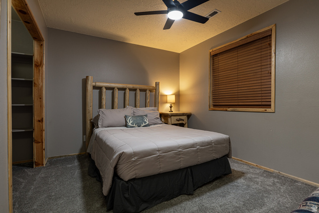 1505 West Elk Ridge Drive Alton, UT 84710 - Photo 40 of 53 Bedroom with a textured ceiling, carpet, ceiling fan, and a closet
