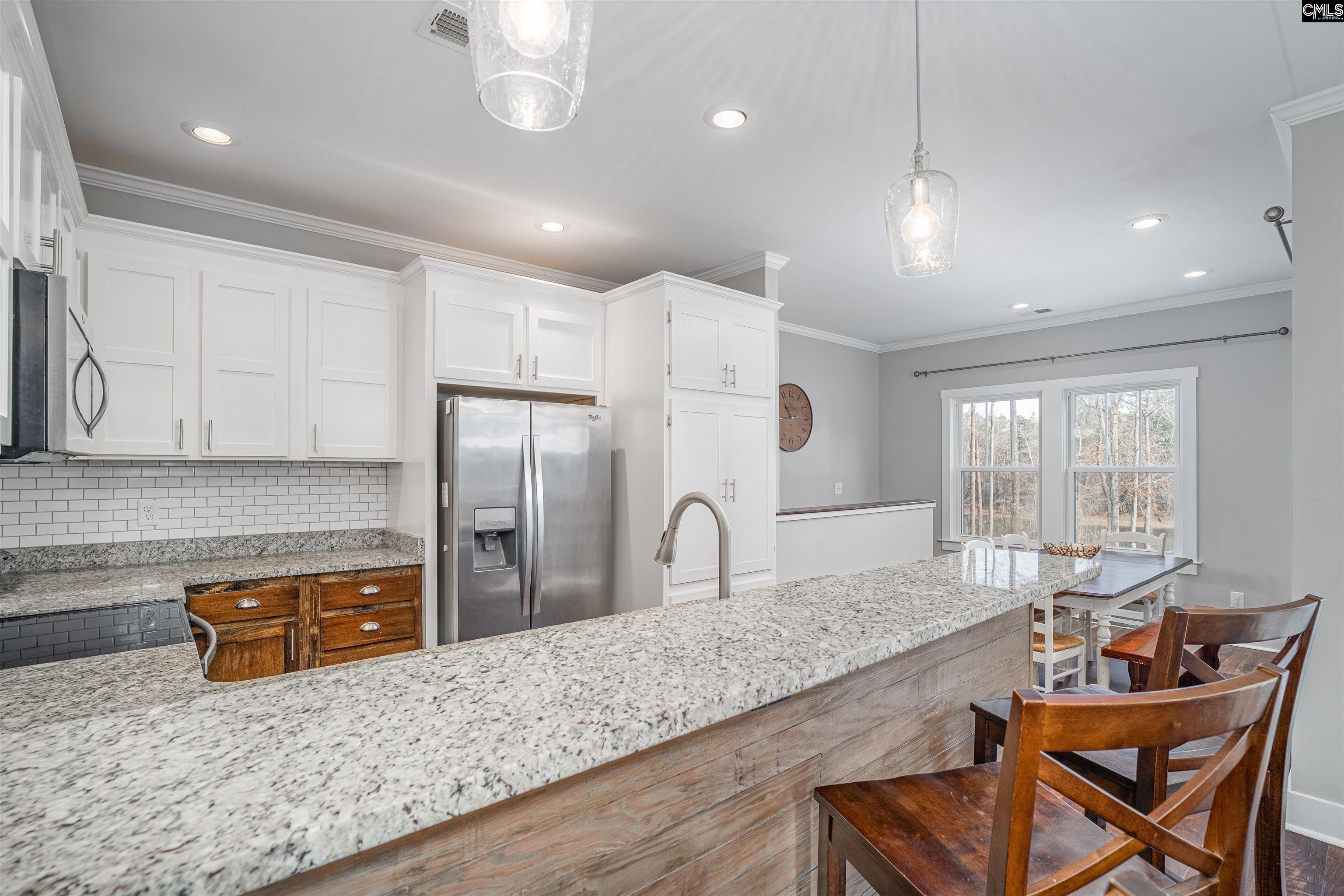 649 Sandbar Road Chapin, SC 29036 - Photo 13 of 40 a kitchen with stainless steel appliances granite countertop a sink refrigerator and cabinets