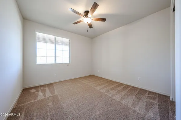 an empty room with windows and fan