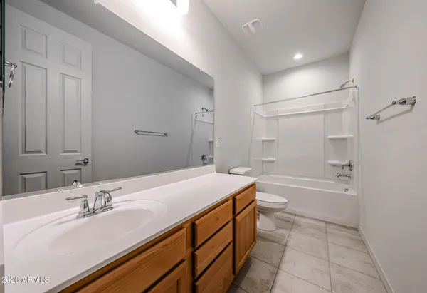a bathroom with a granite countertop sink mirror toilet bathtub and vanity