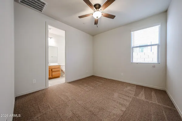 an empty room with windows and fan