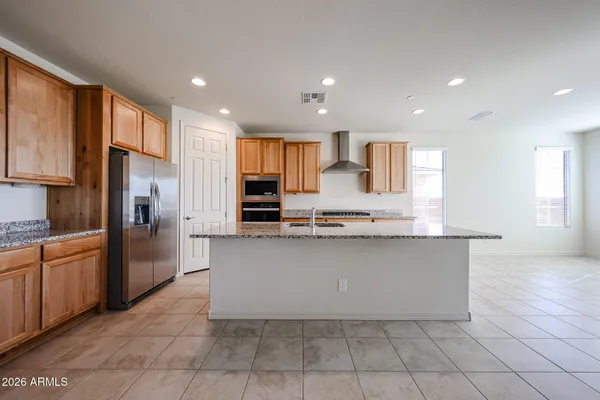 a large kitchen with a large counter top stainless steel appliances and cabinets