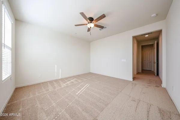 an empty room with ceiling fan and window