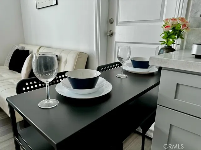 a table with chairs and a vase of flowers on it