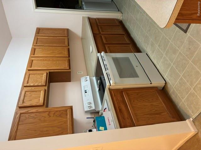 11840 Farmington Road, Unit 59 Livonia, MI 48150 - Photo 5 of 16 Full kitchen with wood-finish cabinetry, light-toned countertops, a white range, and tiled flooring